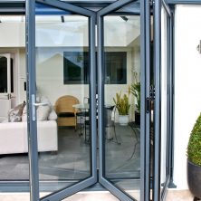 An image of bifold glass patio doors on a modern house