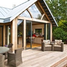 An image showing the exterior of a home with bifolding doors leading onto decking in Harrow.